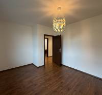 A room in a family house with white walls and a wooden decor floor.