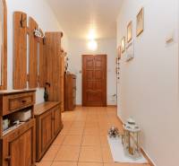 A hallway in a 3-room apartment with ceramic tiles and wooden furniture.