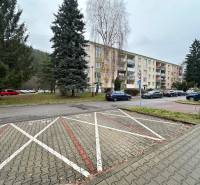 Apartment building on SNP Street in Považská Bystrica surrounded by greenery and a parking lot.