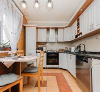 Rustic kitchen with a corner unit, dining nook, and appliances in a 3-room apartment.