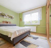 A bedroom in a 3-room apartment with a wooden decor floor and green walls.