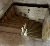 Concrete staircase in a family house with walls made of white blocks.