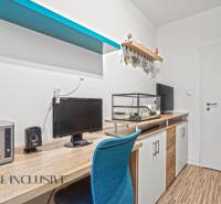 A desk with a computer and an aquarium, a floor with a wooden decor, a blue shelf.