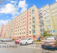 Apartment building in Bratislava - Vrakuňa, parking lot with cars and blue sky above a 3-room apartment.