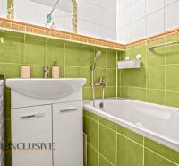 Bathroom with colorful tiles and a bathtub in a 3-room apartment, vibrant shades of green.