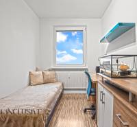 Children's room with a bed, desk, and aquarium in a 3-room apartment with a wooden decor floor.