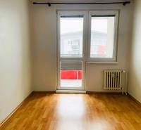 A room in a 3-room apartment with a wooden decor floor and balcony doors.