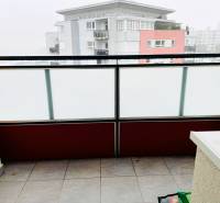A balcony with milk-colored railings and a view of the surrounding buildings in Bratislava - Karlova Ves.