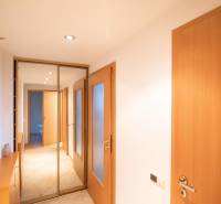 An entrance hall with a large mirrored wardrobe and tiles in a 2-room apartment.