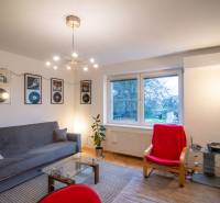Living room in a two-room apartment with a wooden decor floor and wall decorations.