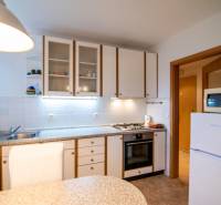Kitchen in a 2-room apartment with a white kitchen unit, stove, and refrigerator.