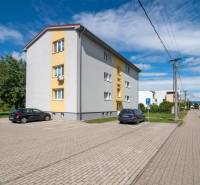 Apartment building on SNP Street in Ivanka pri Dunaji with a parking lot and a sidewalk.