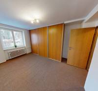 A room with carpet flooring and a built-in wardrobe in a 2-room apartment.