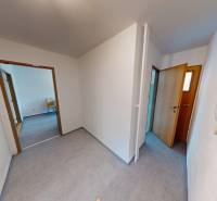 A hallway in a 2-room apartment with doors and a light floor.
