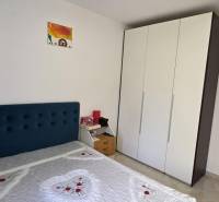 Bedroom in a 3-room apartment with a bed, wardrobe, and a painting on the wall.