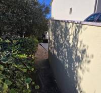 A narrow alley between the house and greenery in Crikvenica, suitable for pleasant walks.