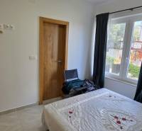 A bedroom in a 3-room apartment with white walls and simple furnishings.