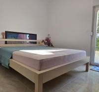 A bedroom with a bed and access to the garden in a 3-room apartment.