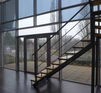 Interior of commercial space with wood-patterned flooring and a staircase.