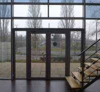Interior of commercial premises with glass doors and a staircase with a wooden decor.