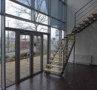 Interior of commercial spaces with wood-patterned flooring and a staircase.