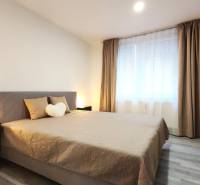 A bedroom in a 2-room apartment with a comfortable bed, a wardrobe, and curtains.