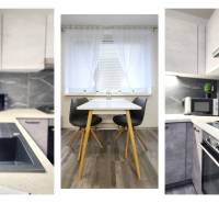 A kitchen in a 2-room apartment with a wooden decor floor and modern appliances.