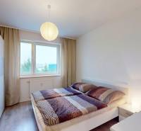 Bedroom with a double bed, wardrobe, and wooden decor flooring in a 3-room apartment.