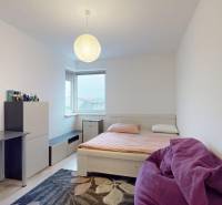 Bedroom in a 3-room apartment with a bed, a desk, and a floor with a wood decor.
