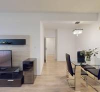 Dining area with TV, glass, and wood-patterned flooring in a 3-room apartment.