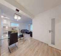 Dining room in a 3-room apartment with a wooden decor floor and a glass table.