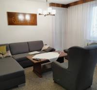 Living room in a three-room apartment with a sofa, an armchair, and a table.