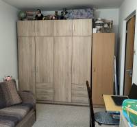 A room in a 3-room apartment with furniture featuring a wooden decor and a sofa.
