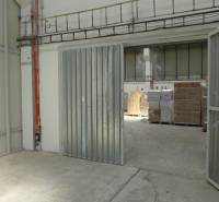 Warehouses and halls with steel gates and pallets of goods.