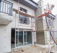 Unfinished facade of a family house in Nové Zámky, scaffolding, large windows, and balconies.