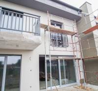 A family house in Nové Zámky during renovation, with construction scaffolding and glass doors.