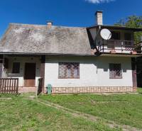A cottage in Dolné Strháre with a grassy plot surrounded by greenery and trees.