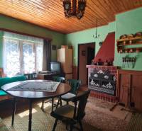 A wooden ceiling, fireplace, and traditional furniture in the cottage adorn the living room.