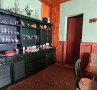 A cottage with a rustic interior, green cabinet, glass cups, wooden decor, carpet.