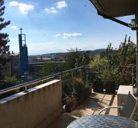 A balcony of a family house on Mozartova Street with a view of the church tower in Bratislava.