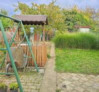 The garden of a 3-room apartment on Vajanského Street in Šaľa with a swing and a well.
