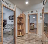 Interior of a 3-room apartment with wood-decor flooring, wall decorations, mirror.