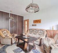 Living room in a 3-room apartment with comfortable seating and a wooden decor floor.