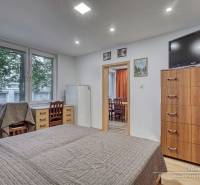 Bedroom in a 3-room apartment with a bed, drawers, and a TV on the wall.