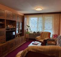 Living room in a 3-room apartment with rustic furnishings, carpets, and curtains.