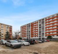 Parking lot and apartment buildings on Hrobákova Street, Bratislava - Háje. You can see cars and trees.