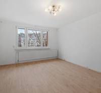 A room with light walls and a floor with a wood decor in a 4-room apartment.
