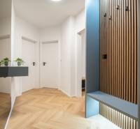 A hallway in a 3-room apartment with a wooden decor floor and wardrobe cabinets.