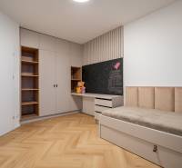 Children's room with a bed, wardrobe, shelves, and a floor with a wooden decor.