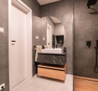 Bathroom with a shower, ceramic tiles, and a sink in a 3-room apartment.